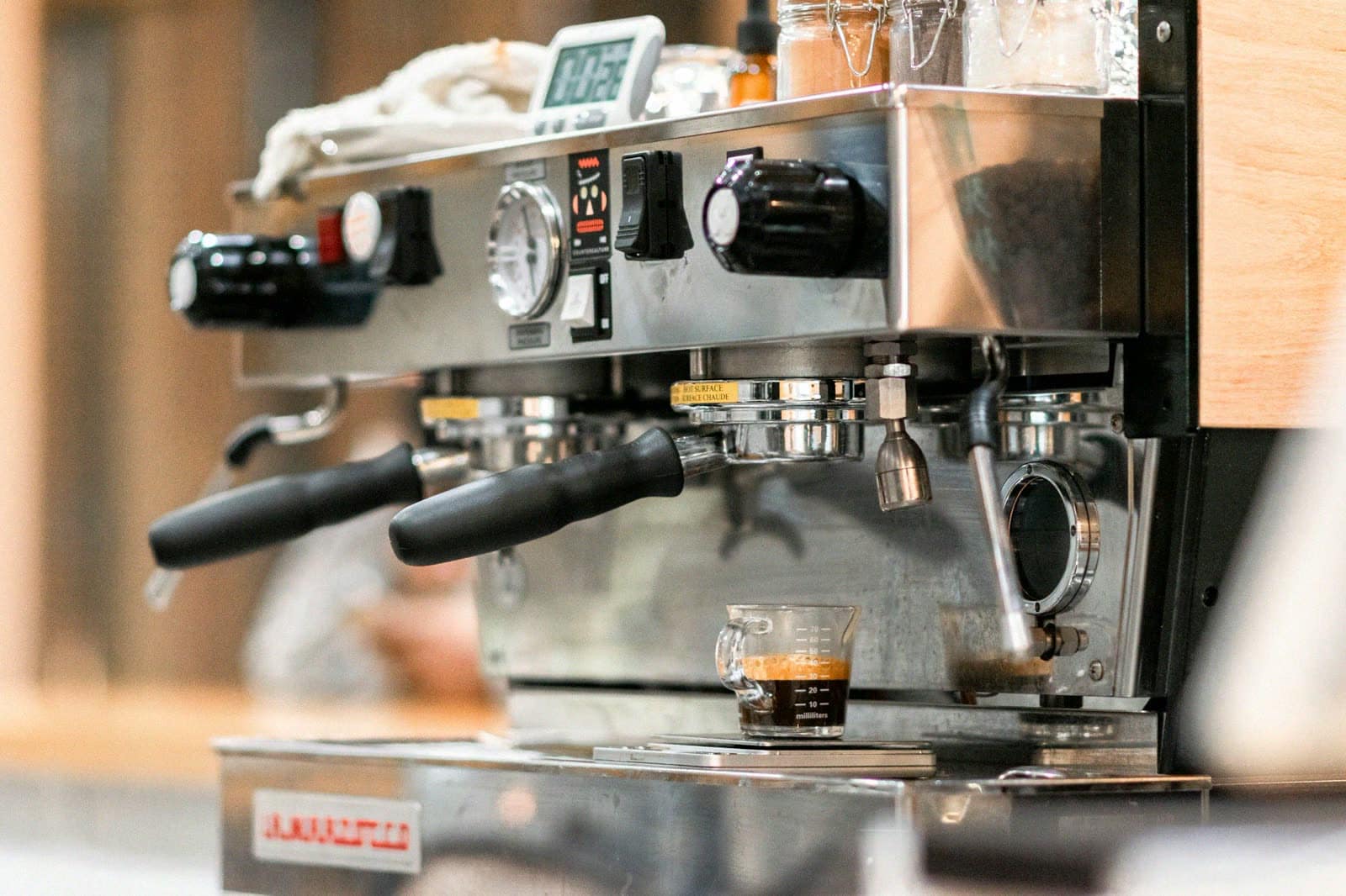 A two-group espresso machine pulling a shot