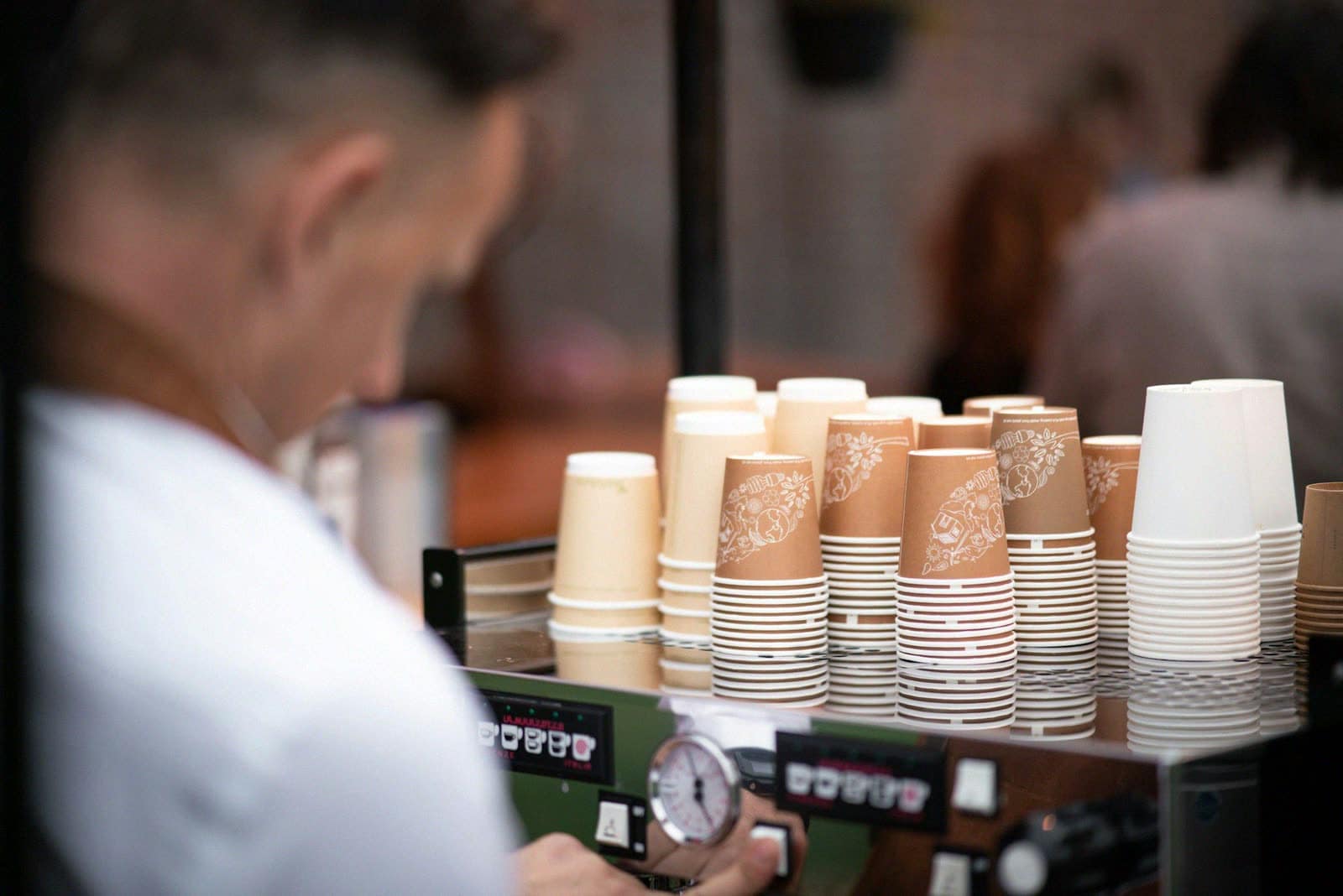 Stacks of paper cups on top of an espresso machine