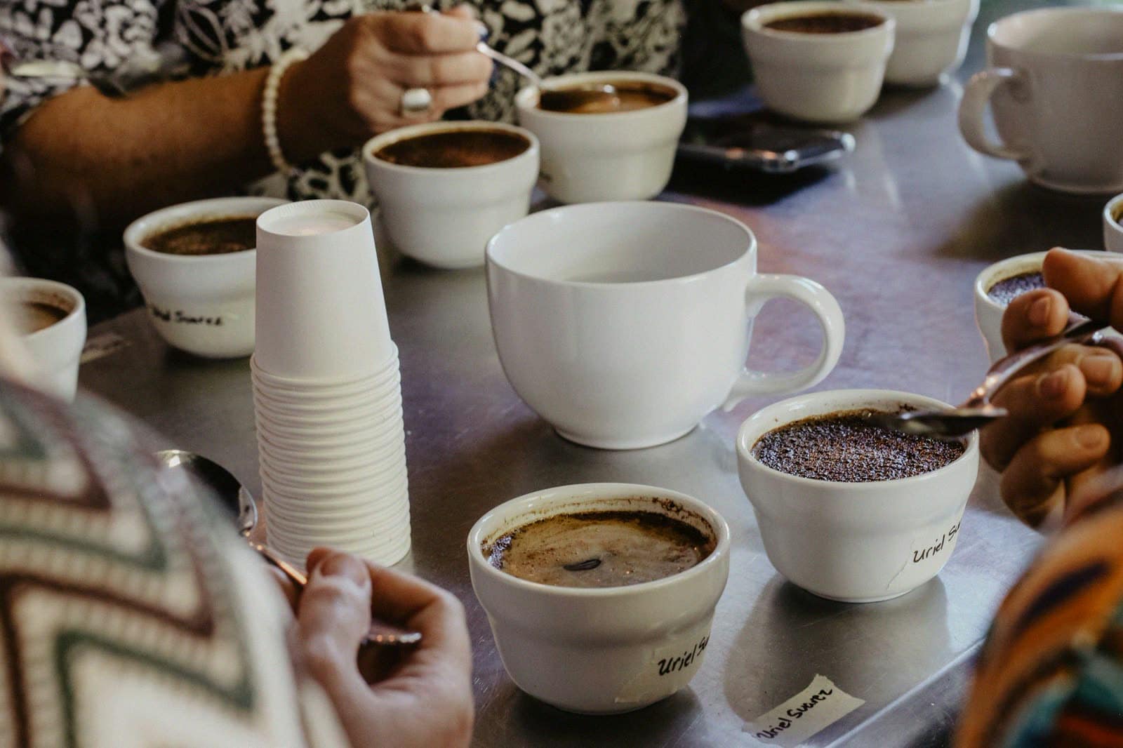 Guests around a table of coffee cups and stacked paper cups